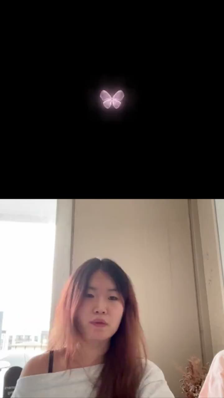 A glowing butterfly on a black background, above a person talking to the camera