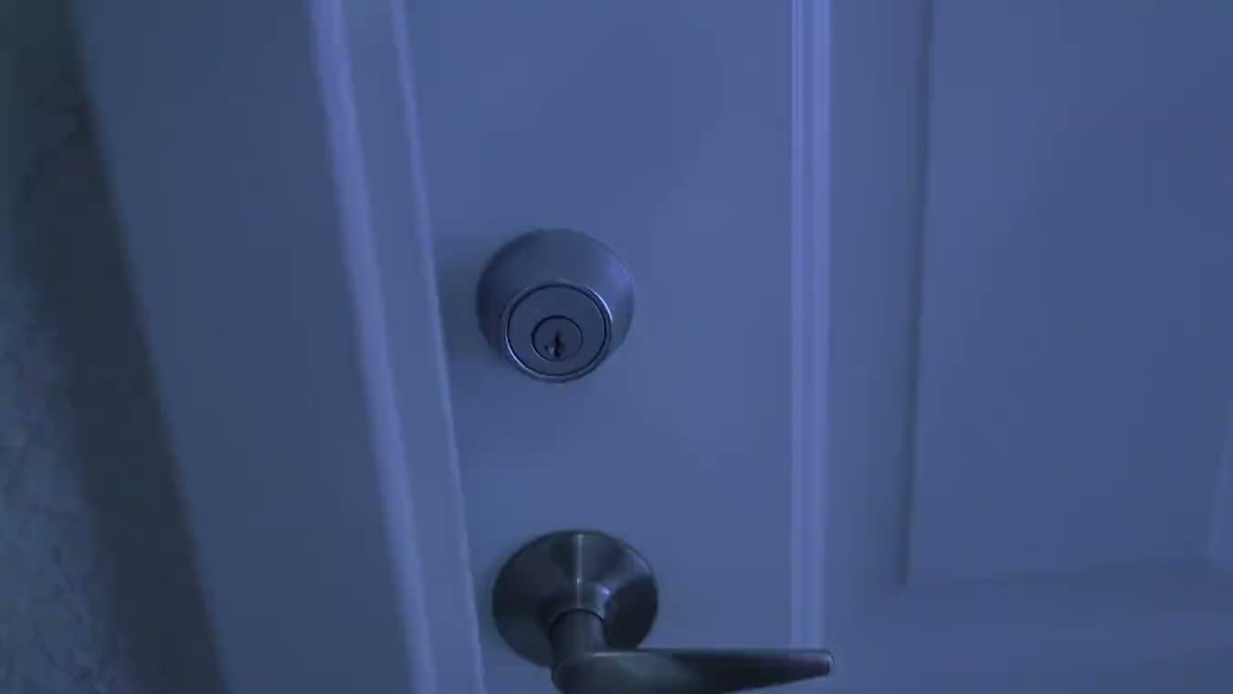 A door handle and deadbolt on a door in blue light